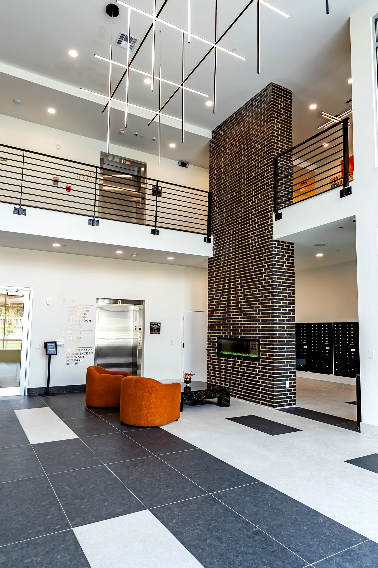 Lobby with the elevator, brick column, and an orange chair