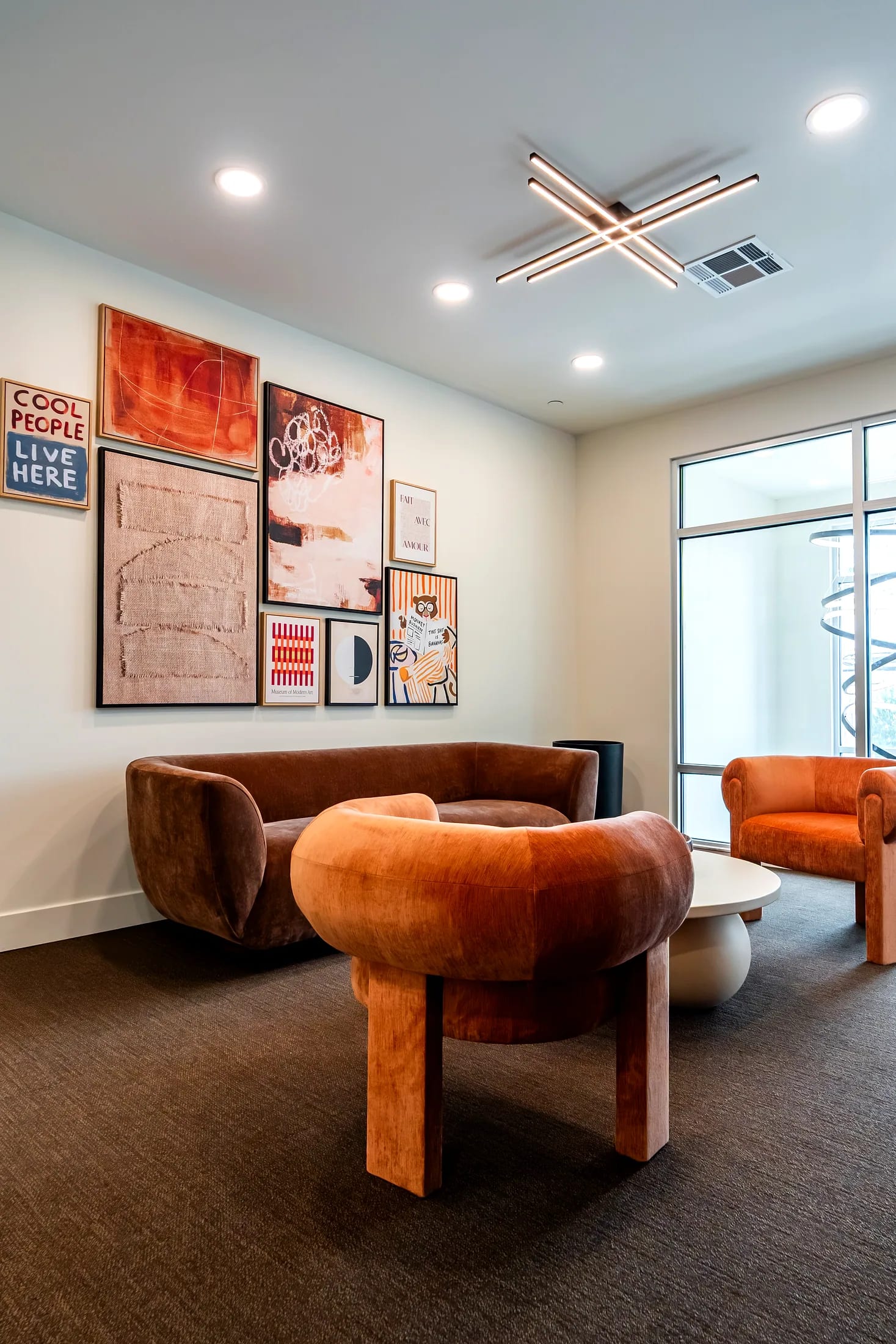 Resident lounge with a velvet sofa and gallery wall