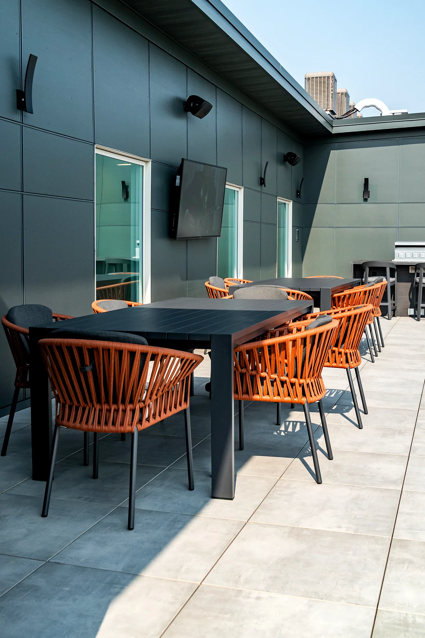 Mesa de comedor con sillas de cuerda en terracota en la terraza norte de Five85West