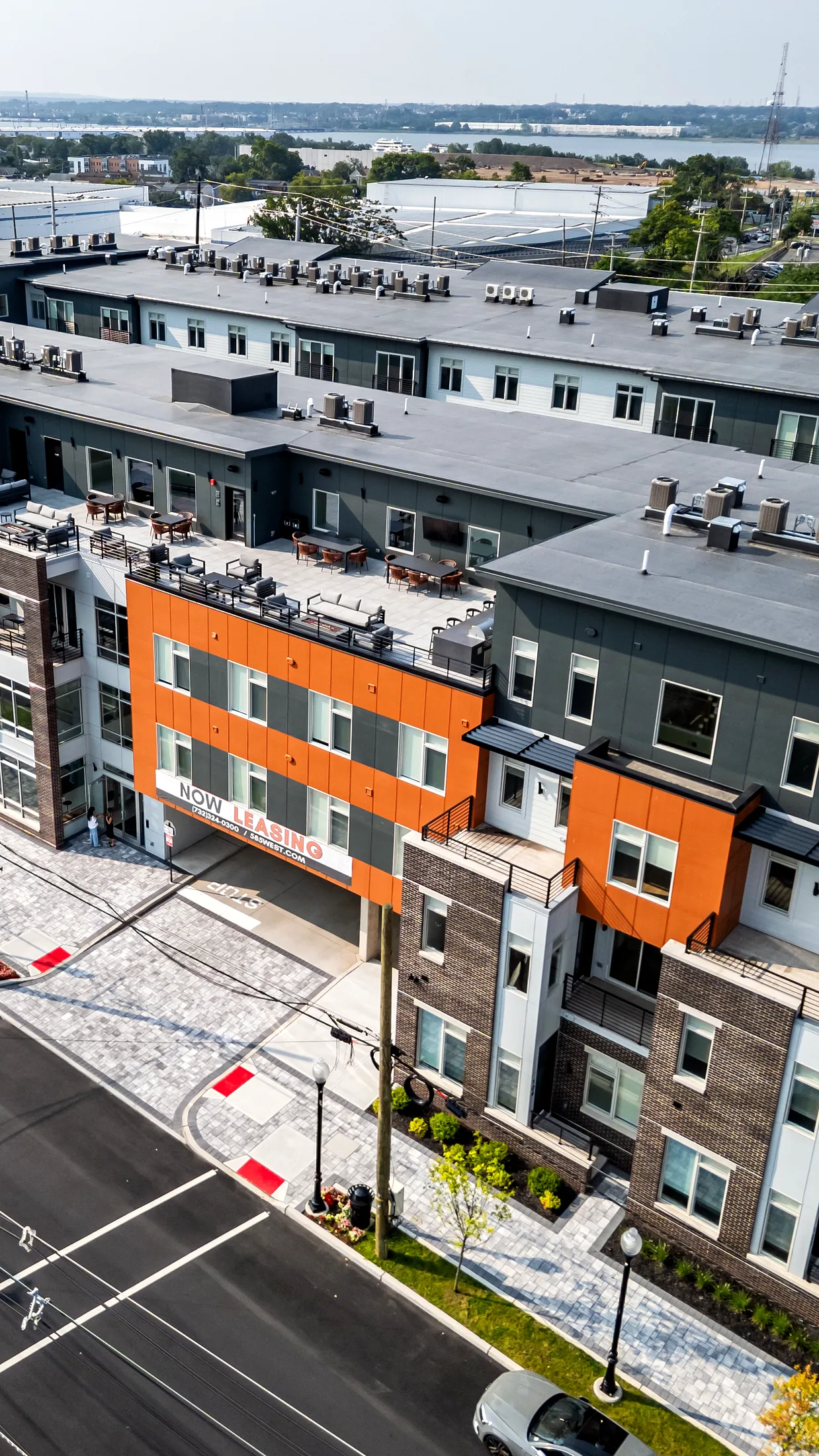 La hilera de townhomes de Five85West vista desde arriba, con paneles naranjas y entradas privadas